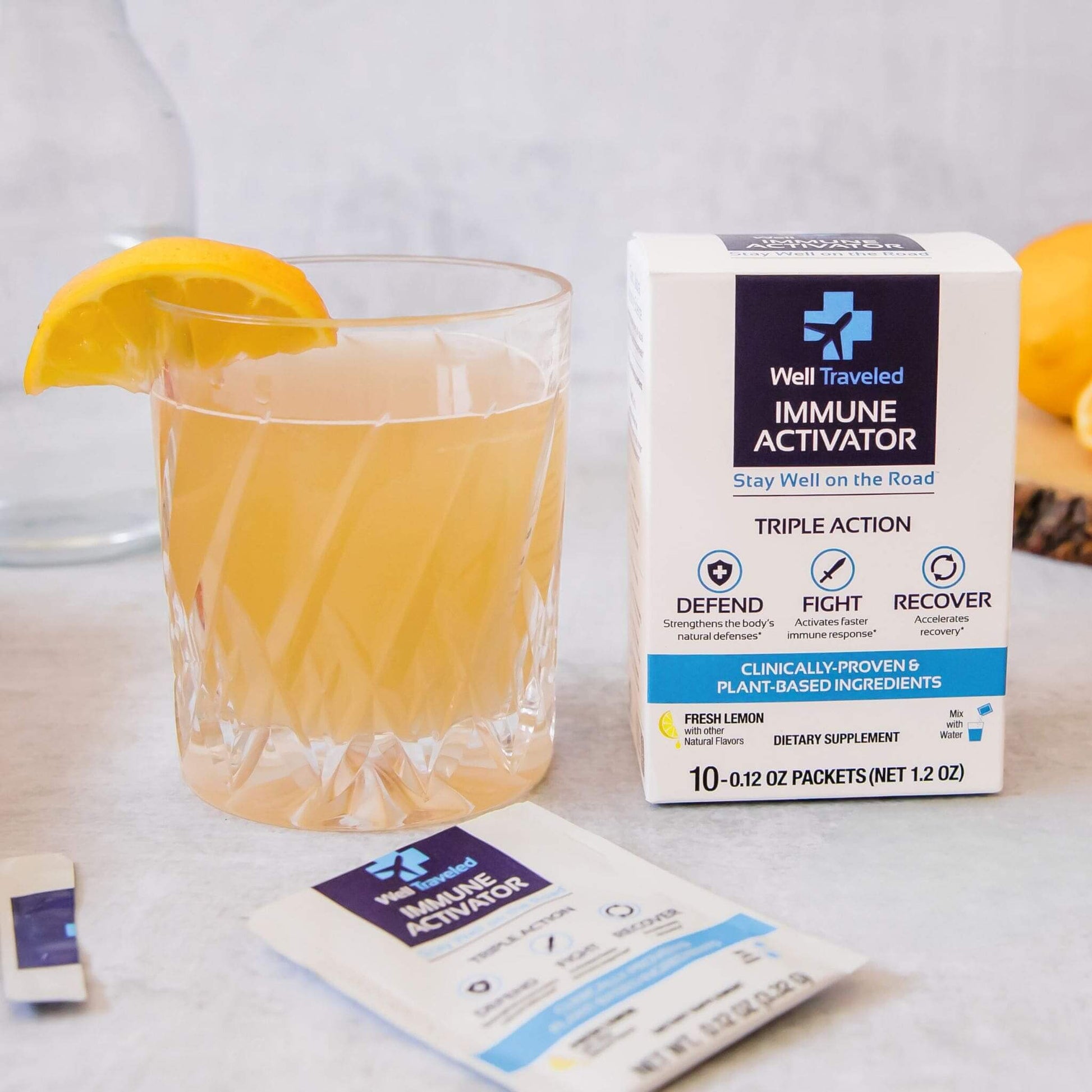 well traveled box and open packet next to glass with liquid and lemon