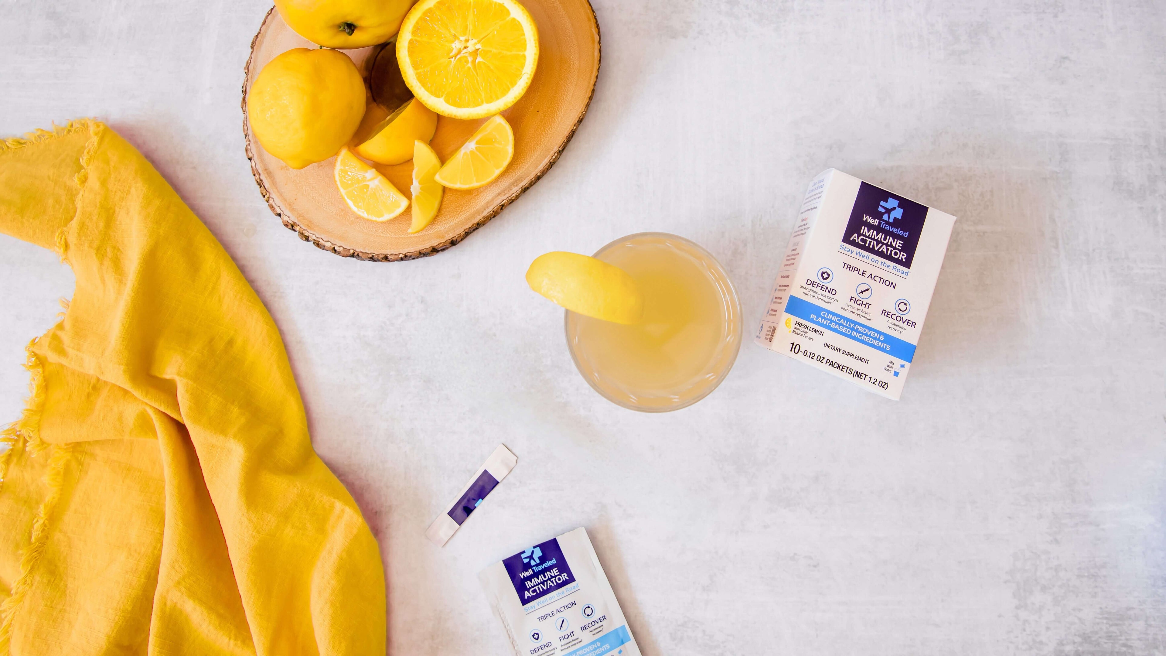 overhead view of well traveled box and open packet and glass with lemons and yellow napkin